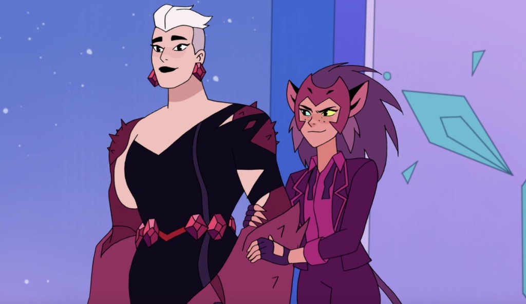 Two women attend the Princess Prom together - one in a purple suit and another in a tight black dress that fits the shape of their muscular body.