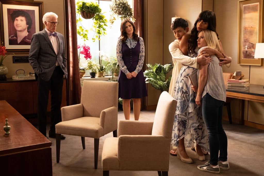 Eleanor, Tahani and Jason engage in an awkward hug whilst Janet and Michael watch, confused.
