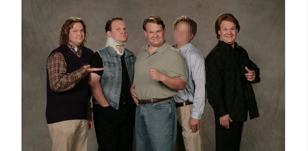 A still from a cutaway gag showing a family photograph featuring Andy Richter portraying quintuplets. Everyone is looking into the camera besides one of them who is blurred as if to not reveal his identity. 